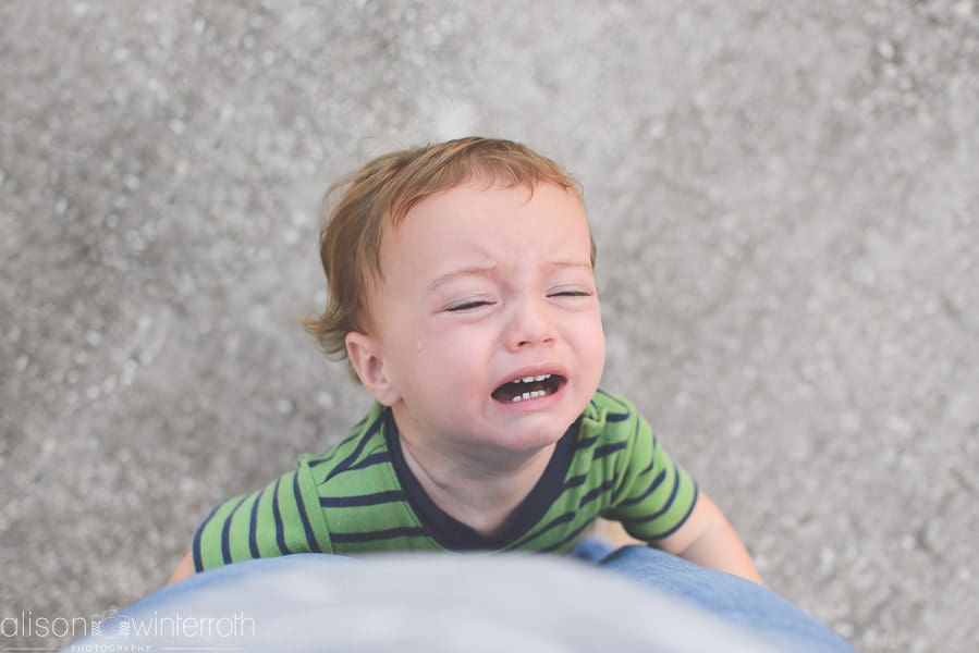 little boy crying hugging mom