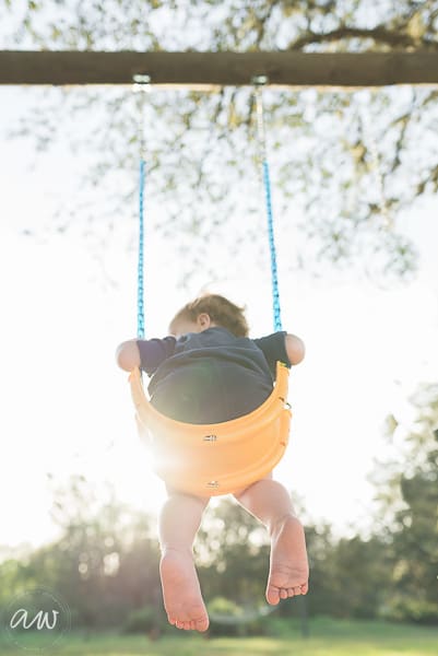 tampa family photographer little boy in swing with sun setting