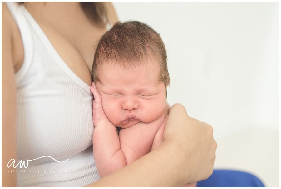 Newborn baby being held by his mom in South Tampa natural light studio. 
