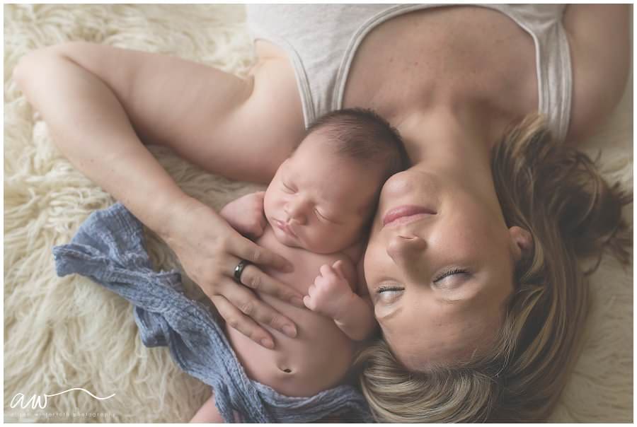Mom snuggling with baby on a cream rug at a Lutz photography session.