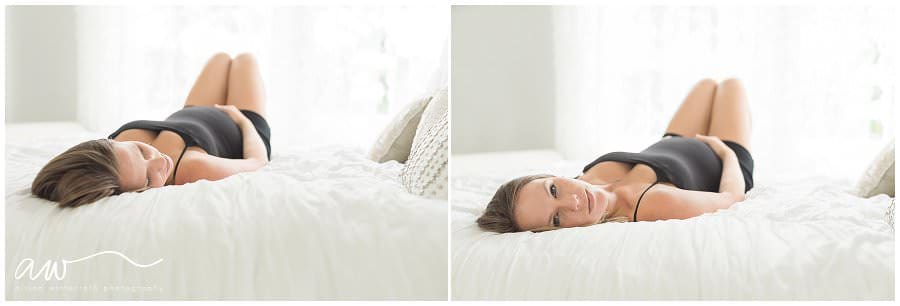 A mom on an all white bed in a natural light studio.