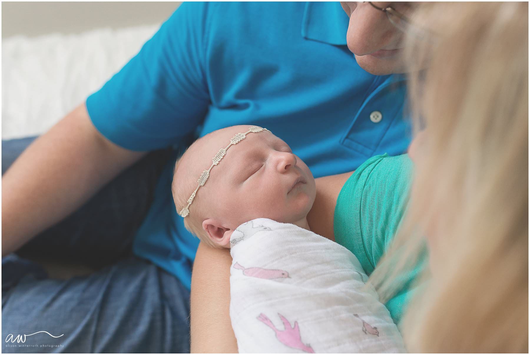 close up of a newborn baby being snuggled by her parents.