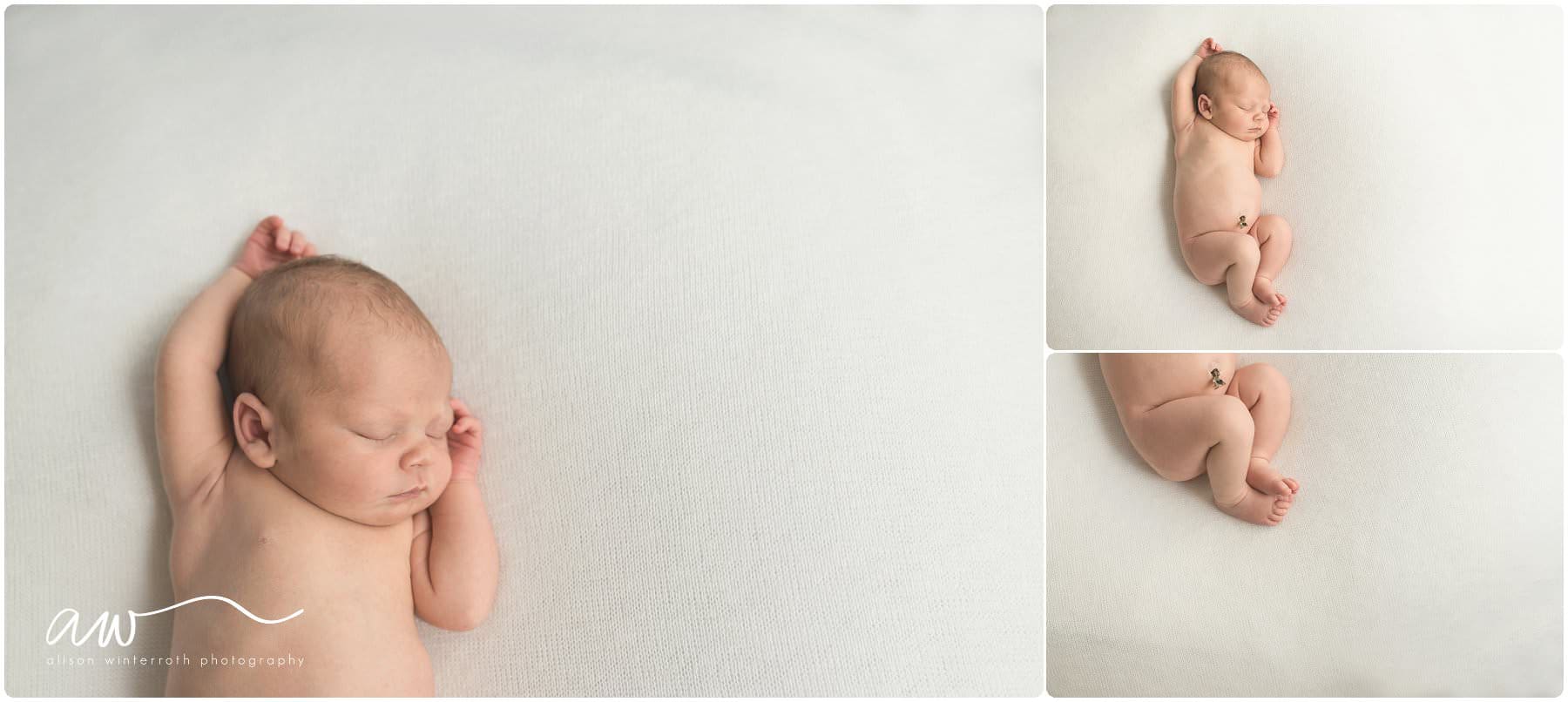 a baby curled up on a white blanket
