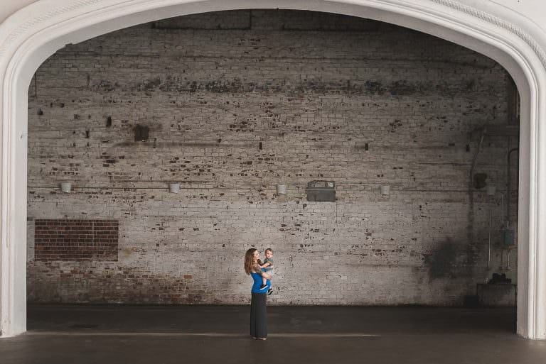 A pregnant woman in front of an exposed brick wall in the Rialto Theatre