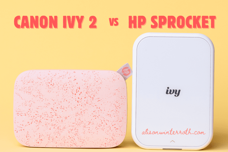 two instant printers lined up. one pink and one white on a yellow surface. One is a canon ivy 2 and the other hp sprocket